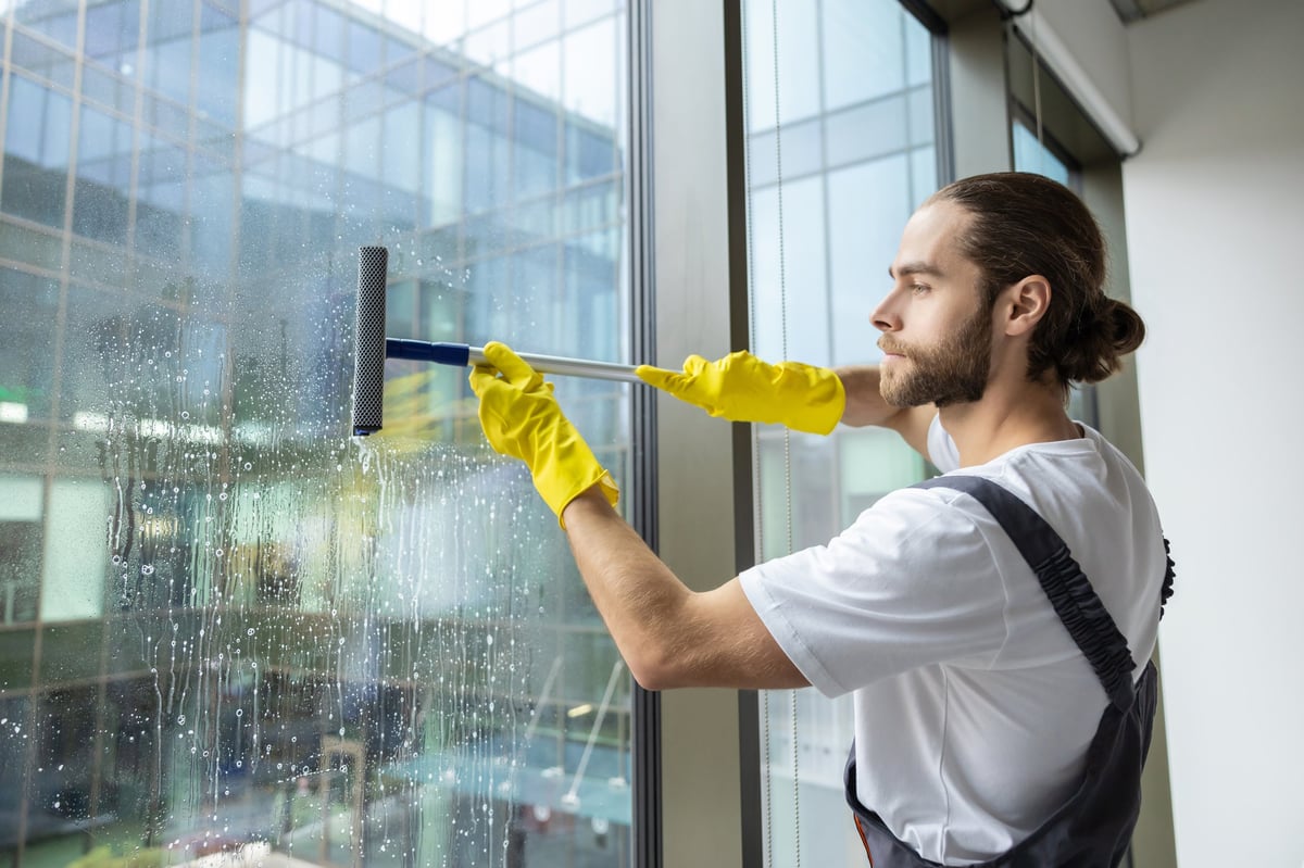 Professional window cleaner working on a home exterior